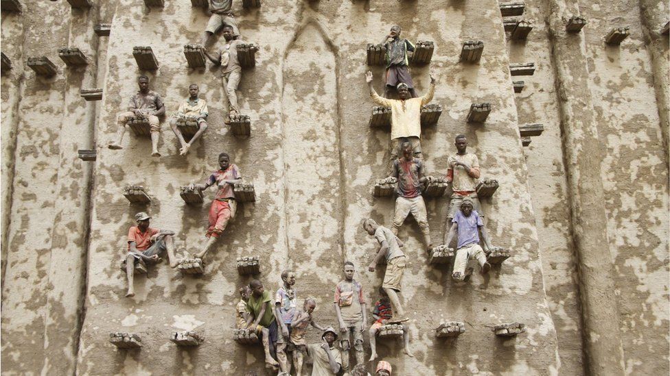 Builders plastering the great mosque of Djenne