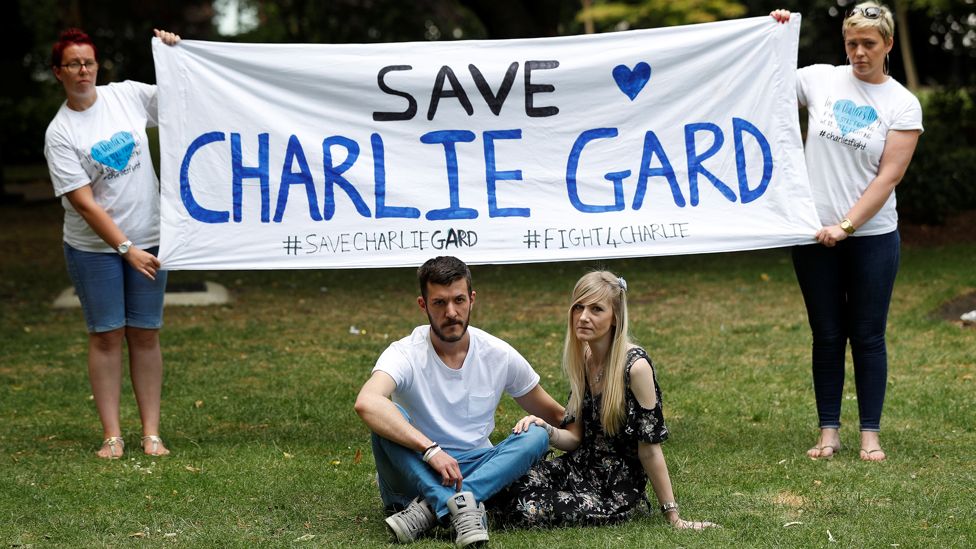 The parents of critically ill baby Charlie Gard, Connie Yates and Chris Gard, pose for photographers as supporters hold a banner, before delivering a petition to Great Ormond Street Hospital, in central London, Britain July 9, 2017