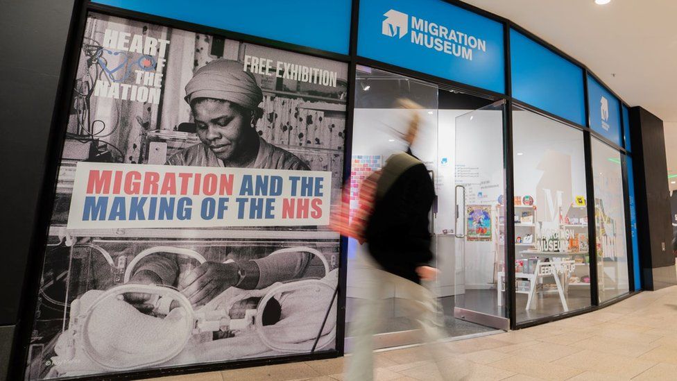 A person walks past the Migration and the Making of the NHS exhibition in Leeds