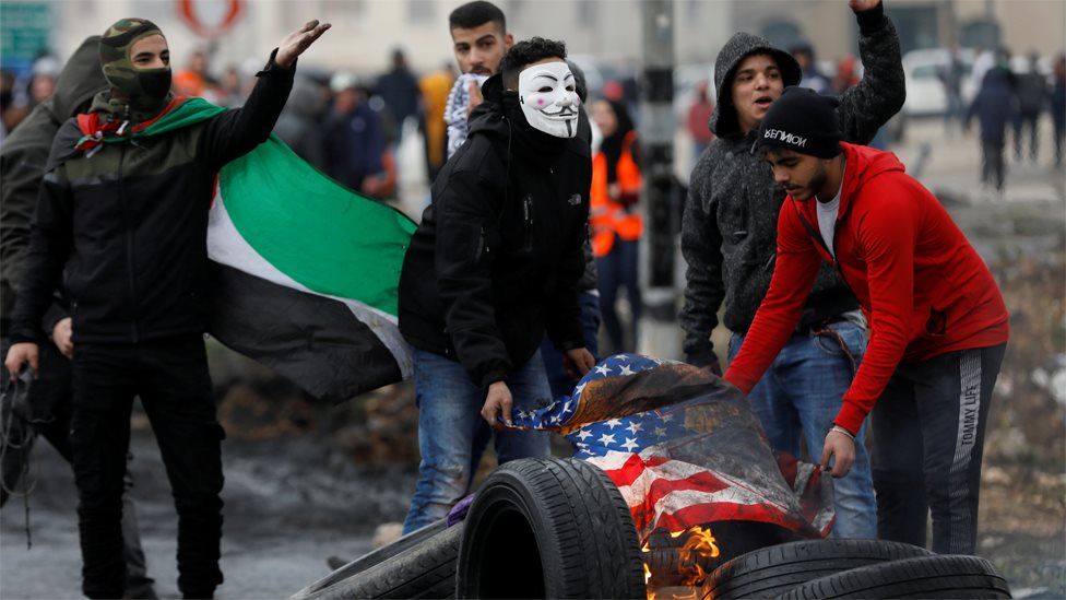 Palestinian protesters burn a US flag during a protest against Donald Trump's peace plan in the occupied West Bank (11 February 2020)