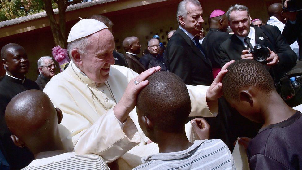 Pope Francis touches children's heads as he visits a refugee camp in Bangui, CAR