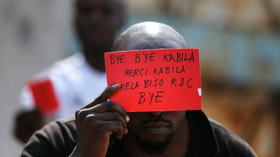 Protester holding anti-Kabila banner