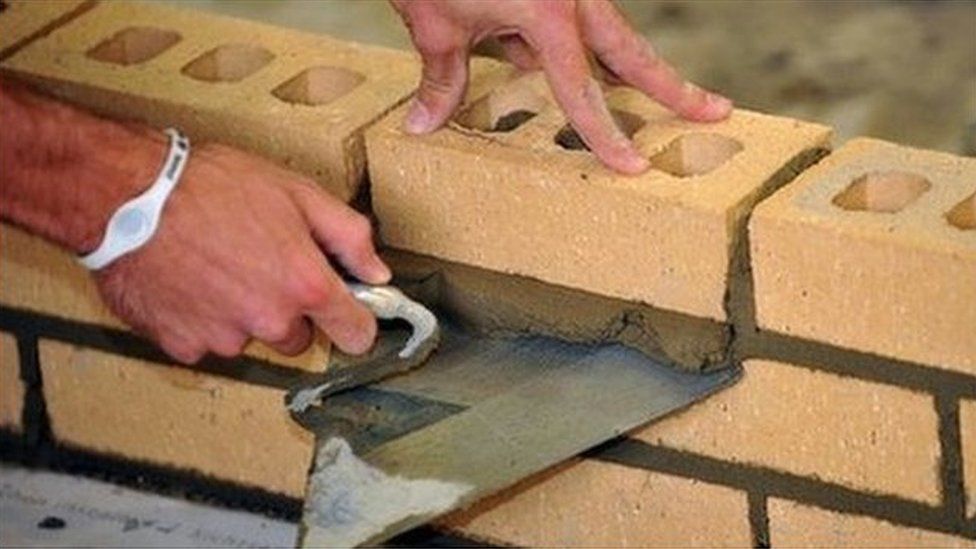 A construction worker laying bricks