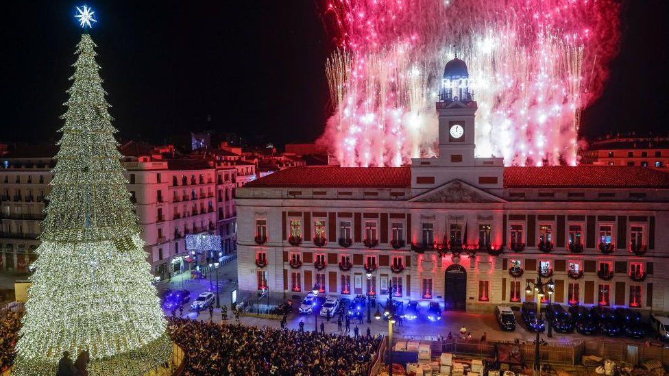 Сотни людей собираются в полночь во время традиционных новогодних курантов в последний день 2022 года и приветствуют 2023 год в Мадриде, Испания, 31 декабря 2022 года