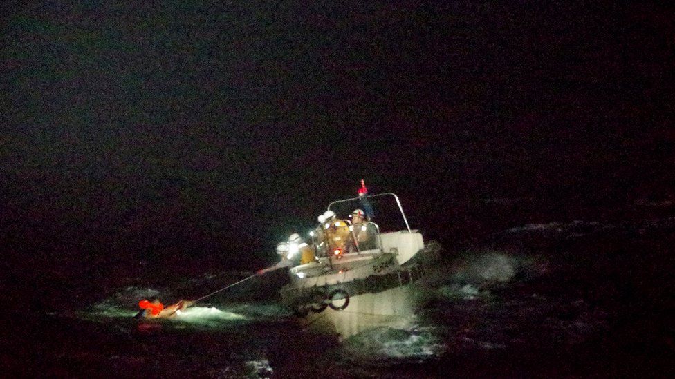Patrol ship pulling seaman out of the water