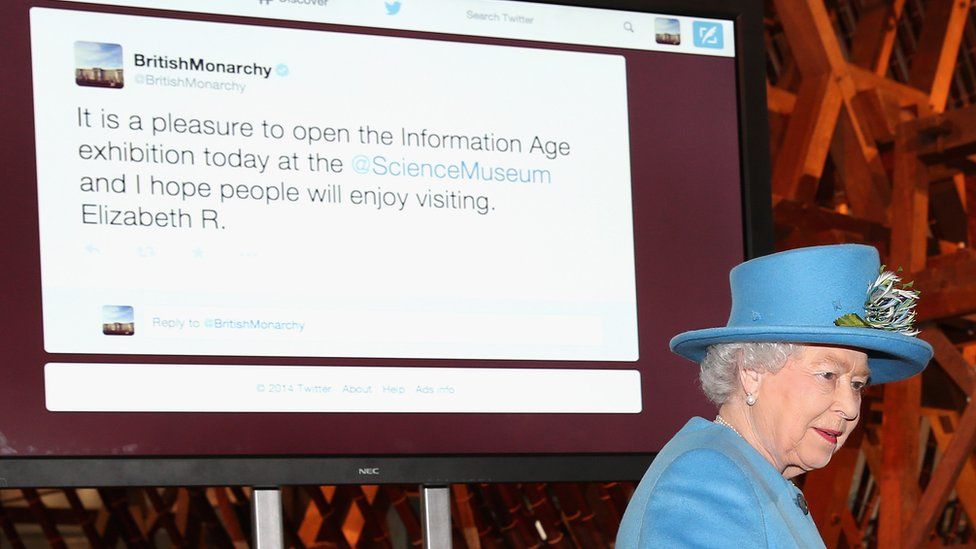 Queen alongside screen showing tweet