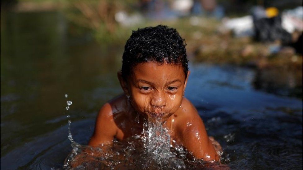 A four-year-old migrant bathes in a river in Oaxaca.