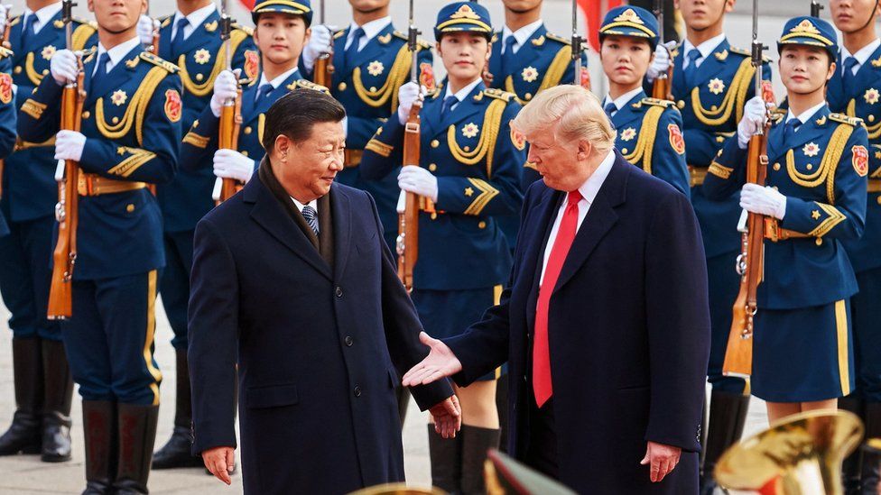 China's President Xi Jinping and US President Donald Trump (L-R front) shake hands during a meeting outside the Great Hall of the People in Beijing in 2017