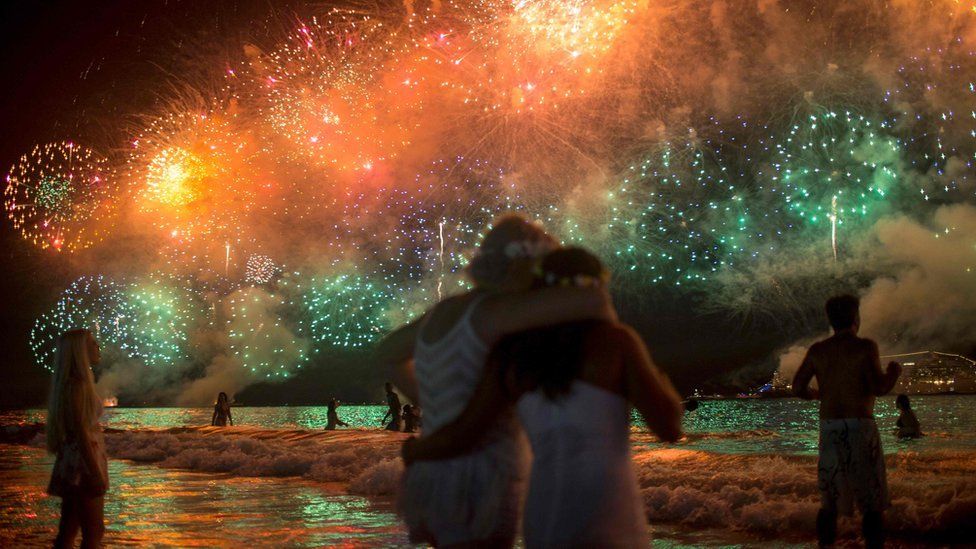 People watch fireworks during New Year's celebrations at Copacabana beach in Rio de Janeiro on January 1, 2018