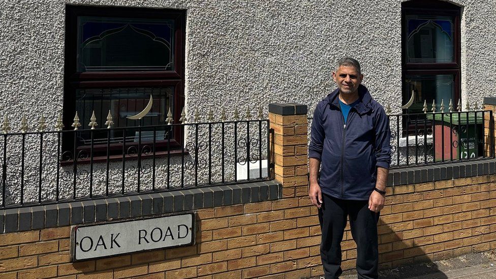 Maqsood Anwar stood outside the Medina Masjid, the community's local mosque and a sign saying Oak Road near the Luton Town ground