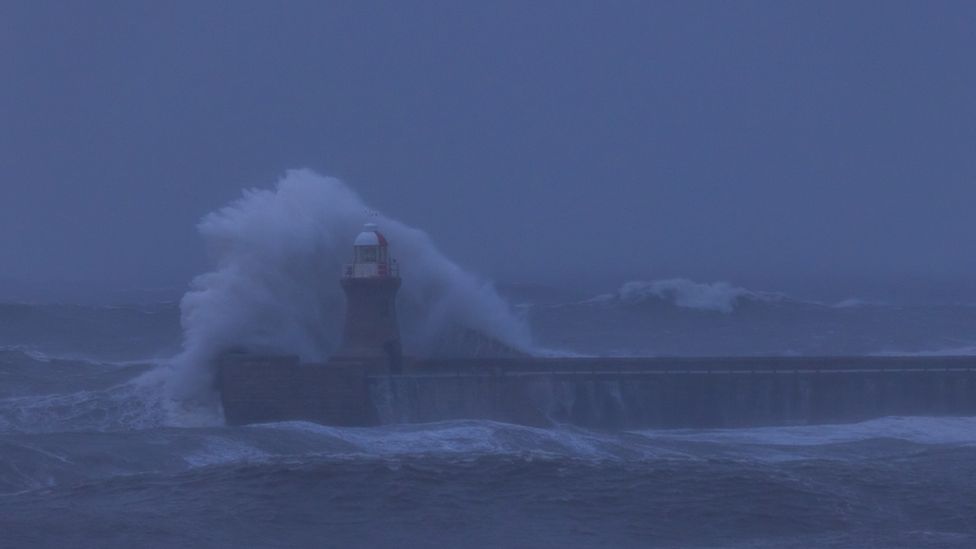 The wave crashes into the pier where South Shields Lighthouse stands