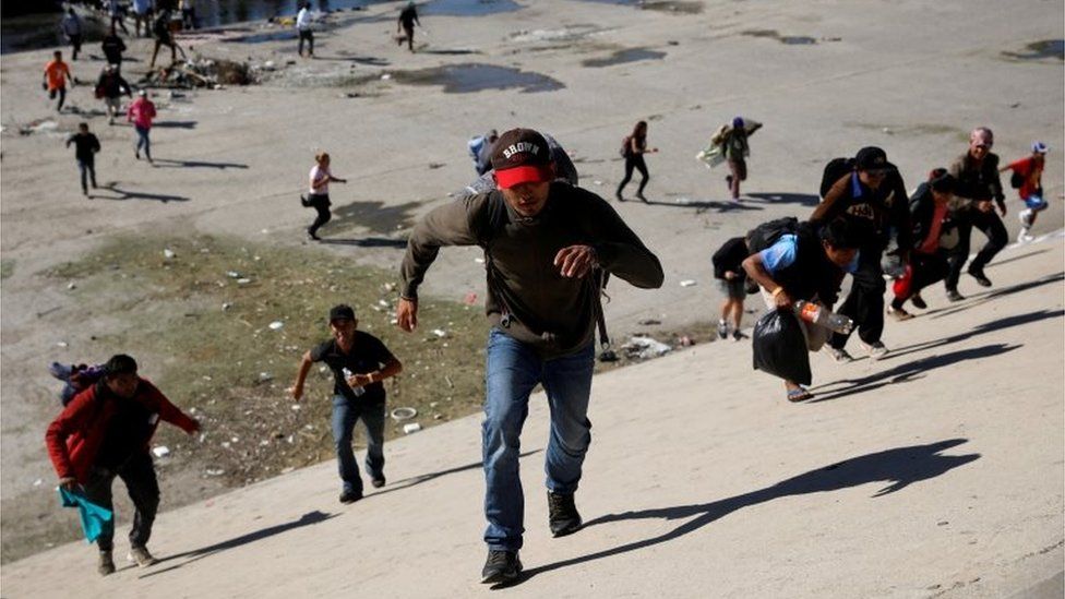 Migrants run across the Tijuana river to reach the border wall between the U.S. and Mexico in Tijuana, Mexico November 25, 2018.