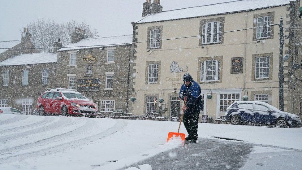 A man clears the roads after heavy snow in Allendale, Northumberland.