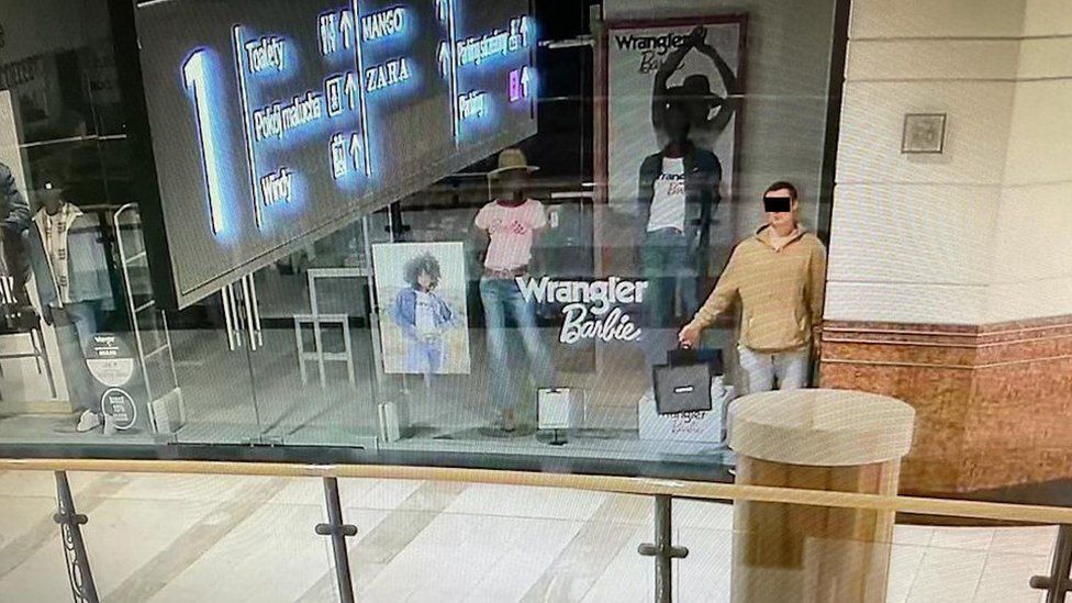 A man pretending to be a mannequin in a shop window