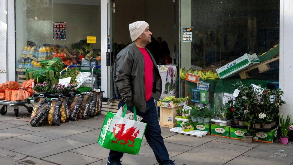 A man walking past a shop