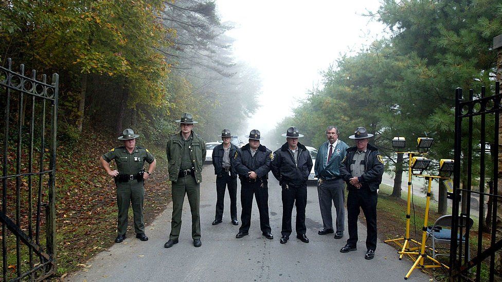 Law enforcement officers stand at the entrance to the Alderson Federal Prison Camp where Martha Stewart turned herself in October 8, 2004