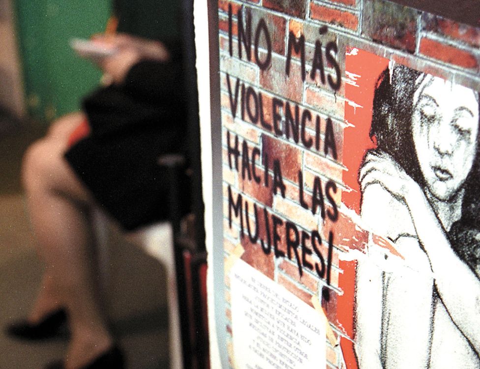 Picture of a girl and writing on a wall that reads "No more violence against women"