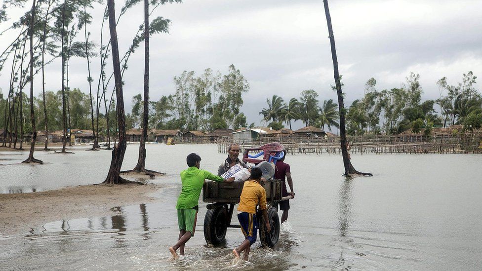 Bangladeshi people walk with their belongings towards a safer area near the coast at the Cox's Bazar district in Chittagong, 30 May 2017