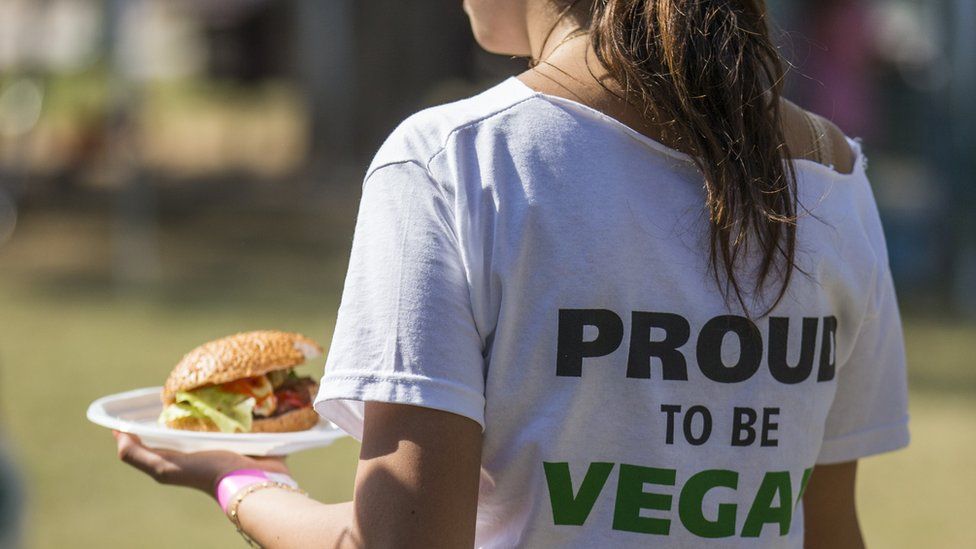 A woman, wearing a shirt reading "proud to be vegan", carries a vegan hamburger during the Vegan Fest fair on 13 October 2014 in the Israeli city of Ramat Gan near Tel Aviv