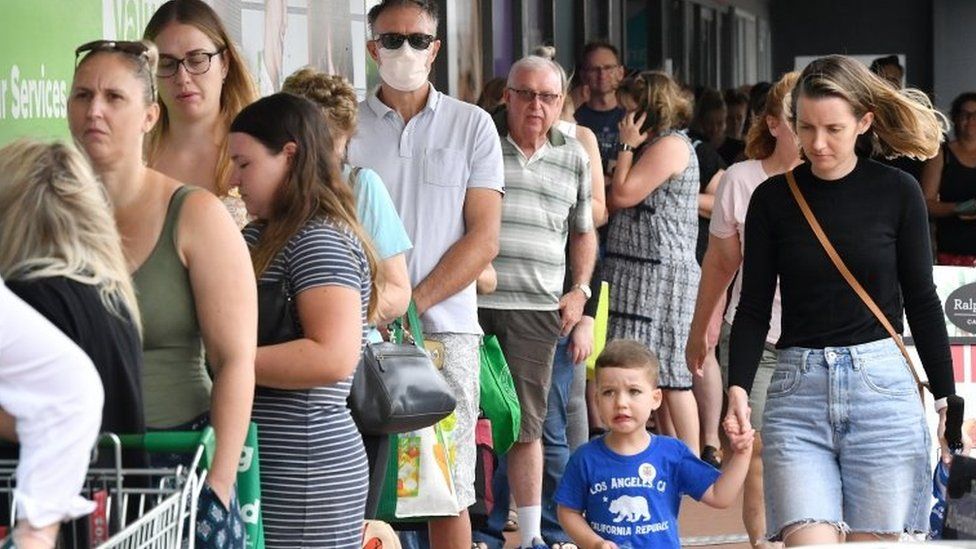 People queue for groceries outside a supermarket in Brisbane on Friday