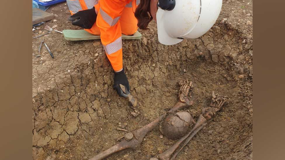 Archaeologist with decapitated Roman burial, Fleet Marston