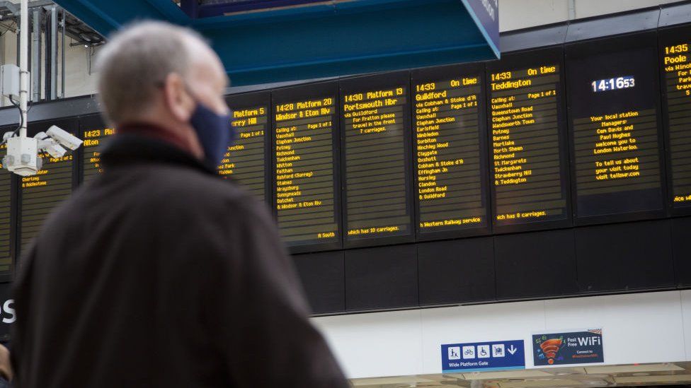 Man looking at departures board in train station