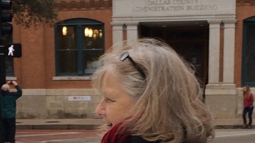 Toni Glover in Dealey Plaza, Dallas, with the Book Depository building in the background