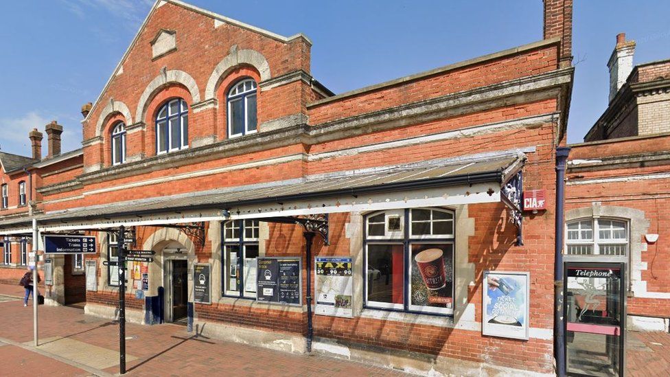The front of the rail station at Salisbury, with blue skies, traditional looking and made from red brick