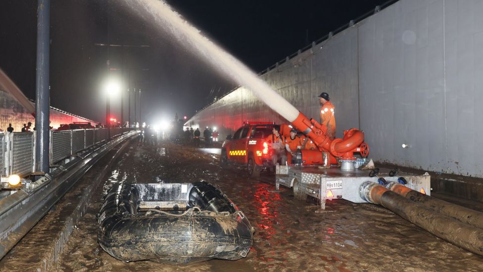 Rescue workers pump water out of a flooded underground tunnel in the town of Osong, North Chungcheong Province, central South Korea, on 17 July 2023, as they search for missing people