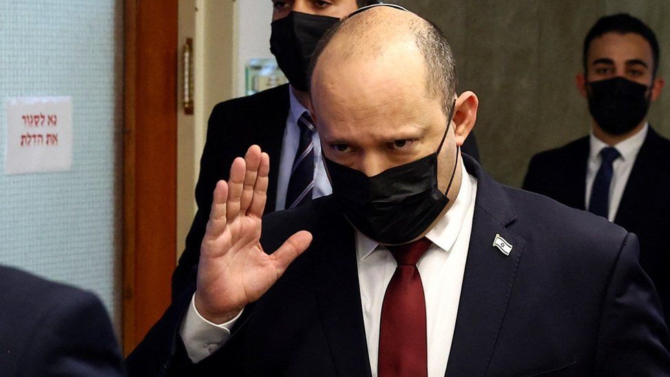 Israeli Prime Minister Naftali Bennett waves to reporters as he arrives at a cabinet meeting in Jerusalem on 6 March 2022