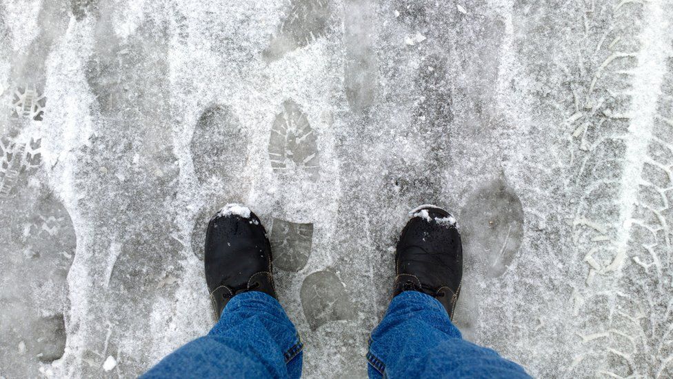 A man's feet standing on ice