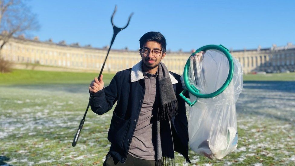 Vivek Gurav holding a litter grabber and bin bag