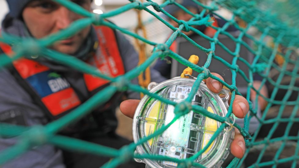 Fisherman holding LED light technology on fishing net