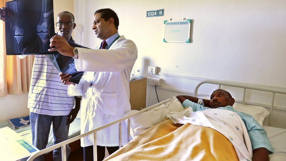 A doctor showing an x-ray to the attendant of a Nigerian patient (R) who underwent surgery at the Apollo Hospital in Chennai, India