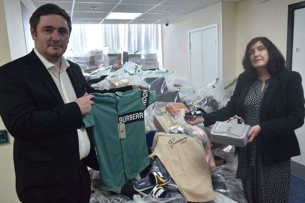 Mayor Chris Cooke and Sinead Upton from Middlesbrough Council’s Trading Standards Team, with the haul of counterfeit fashion goods