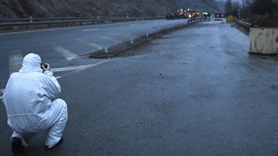 محقق يلتقط صورة لحطام حافلة تحمل لوحات من شمال مقدونيا اشتعلت فيها النيران على طريق سريع