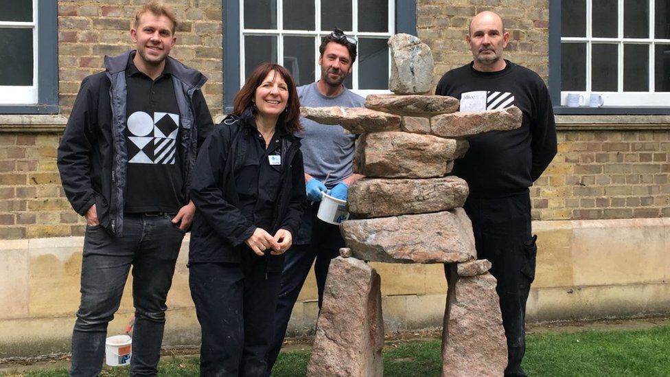 Conservators and installations staff with the newly-restored sculpture