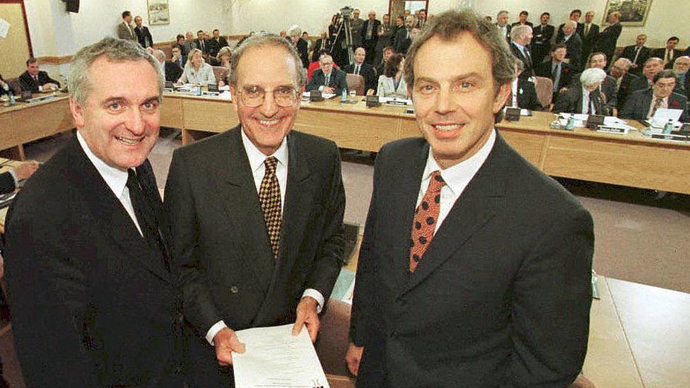 British Prime Minister Tony Blair (R), US Senator George Mitchell (C) and Irish Prime Minister Bertie Ahern (L) smiling on April 10, 1998, after they signed an historic agreement for peace in Northern Ireland,