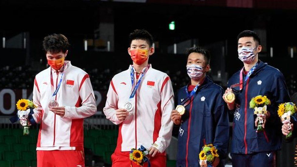 Тай Янг (3-й слева) и тайваньский Ван Чи-лин (3-й справа) позируют со своими золотыми медалями по бадминтону в парном разряде среди мужчин рядом с китайцем Лю Юйчэнь (2-й слева) и китайцем Ли Цзюньху (слева) с их серебряными медалями