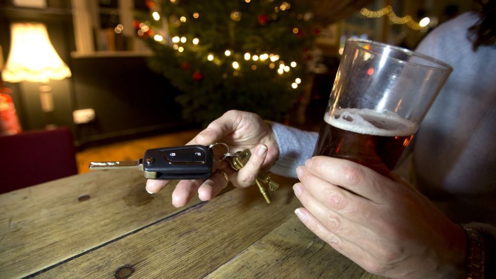 Person holding beer and car keys