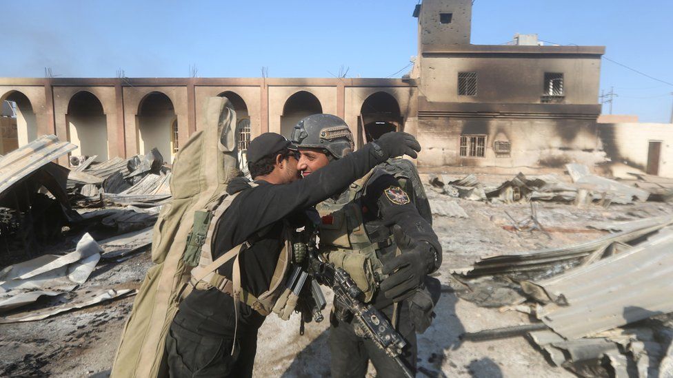 Members of Iraq"s elite counter-terrorism celebrate on December 28, 2015 at the heavily damaged government complex