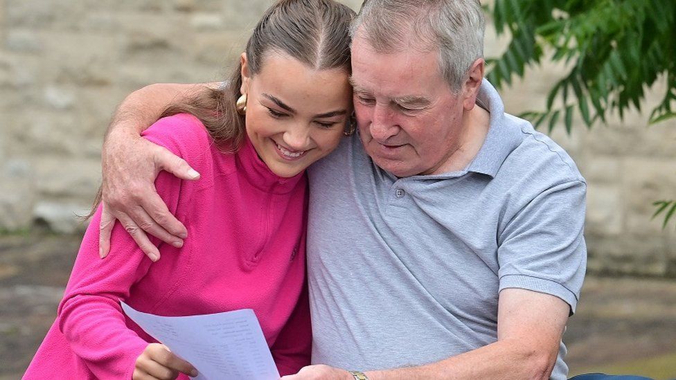 Gabriel Thompson with her grandfather as pupils from St Dominic's Grammar School in Belfast receive their A-level results