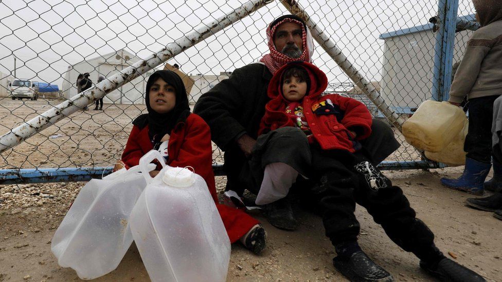 File photo showing a displaced Syrian family wait to fill up water containers at a camp for displaced people in al-Hol, Hassakeh province (17 December 2018)