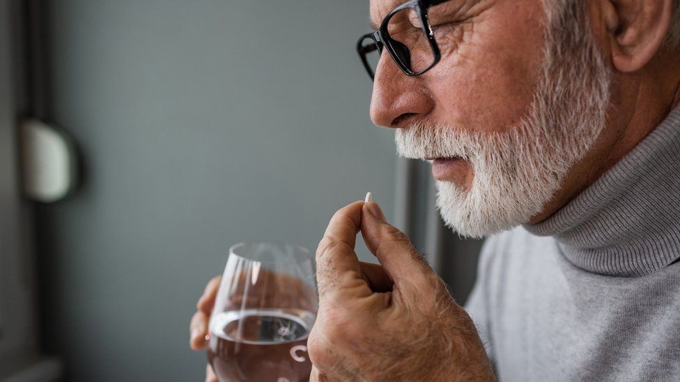 Older man taking a pill