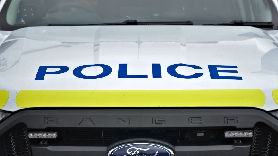 A close-up of the word "police" on the bonnet of a Ford Ranger vehicle