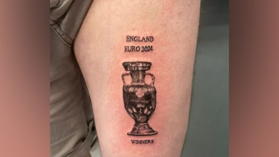 A tattoo of a trophy, with the words "England Euro 2024 Winners" around it