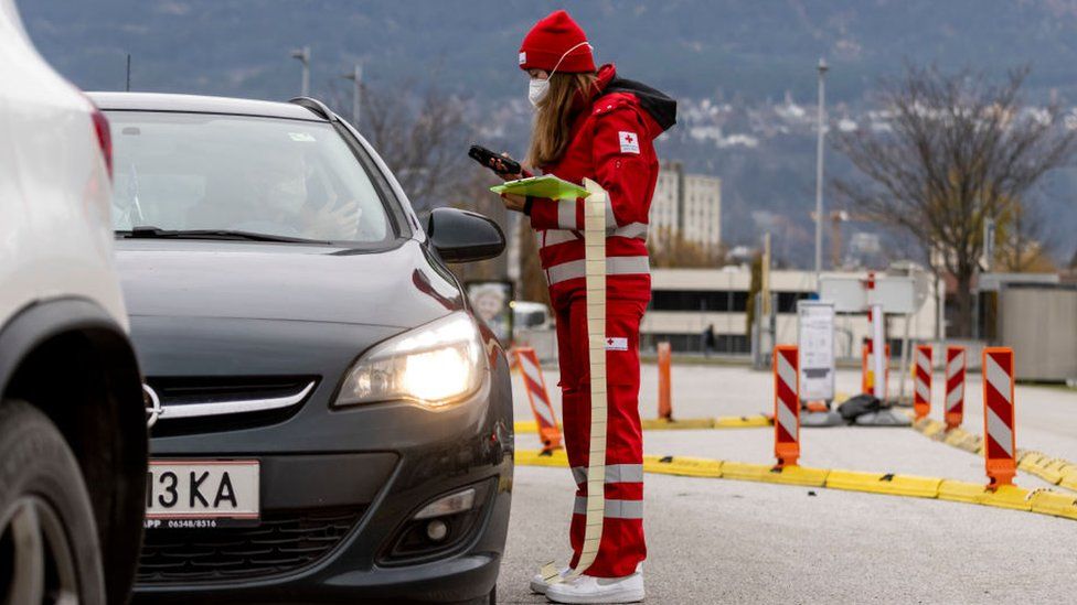 An employee of the Red Cross checks the registrations for the PCR test at a Covid-19 testing station on November 08, 2021 in Innsbruck