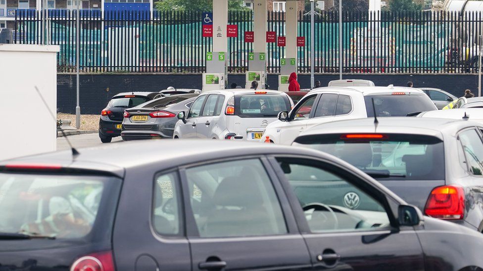 Cars queue at a petrol station forecourt