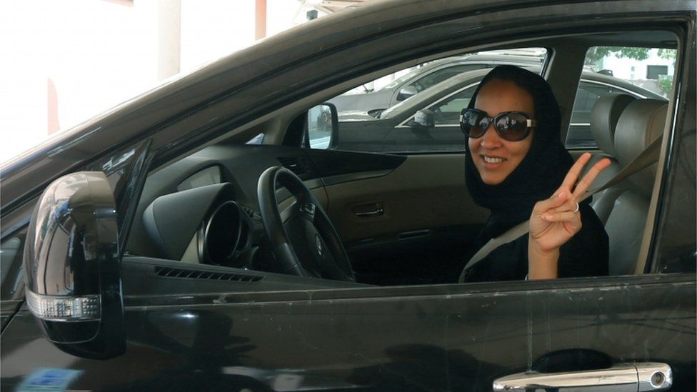 Saudi Arabian activist Manal Al Sharif, who now lives in Dubai, flashes the sign for victory as she drives her car in the Gulf Emirate city on October 22, 2013, in solidarity with Saudi women preparing to take to the wheel on October 26, defying the Saudi authorities, to campaign women"s right to drive in Saudi Arabia.
