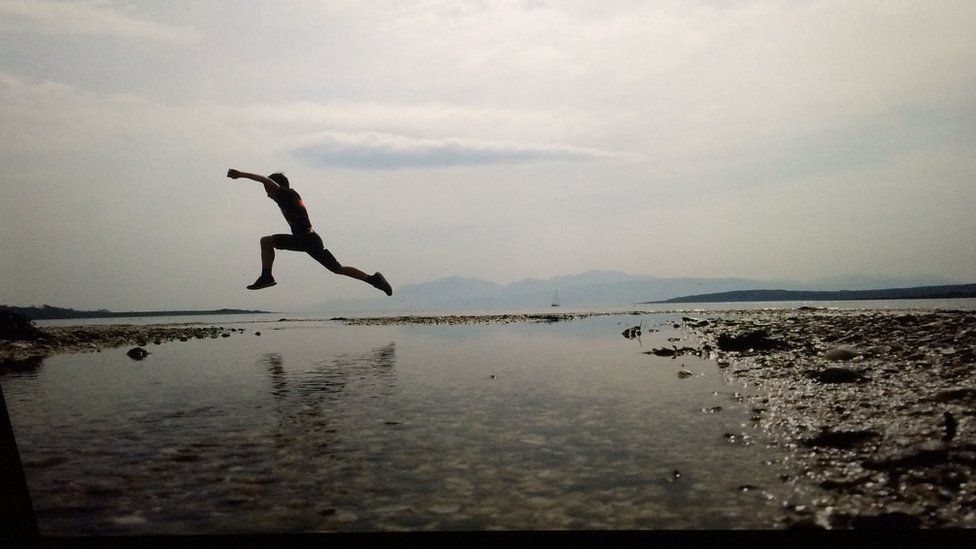 boy leaping over water